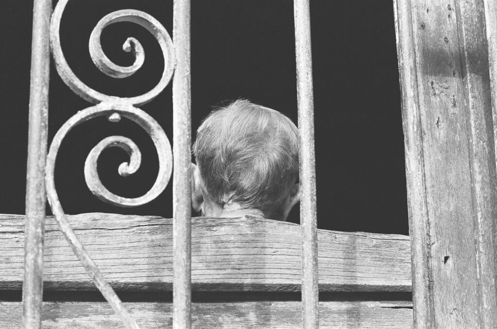 Persona anciana de espadas en ventana antigua.