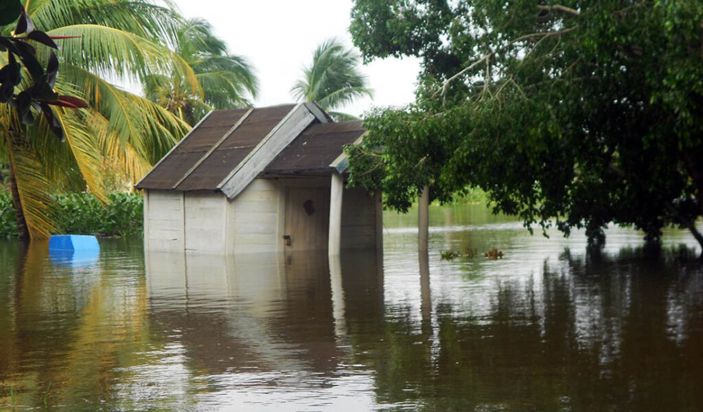 Pequeña casa de madera en medio de una inundación.