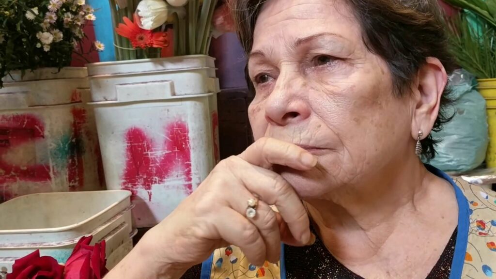 Mujer vendedora de flores. Fotograma de "Calas", audiovisual de Oneyda González.