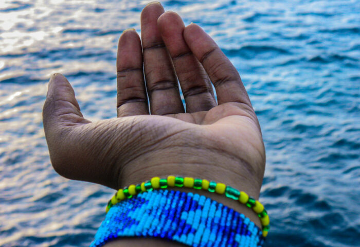 detalle de mano de mujer extendida hacia el mar