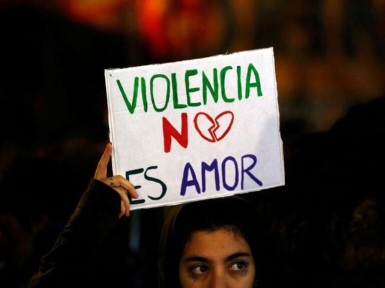 mujer con cartel donde se lee "violencia no es amor"