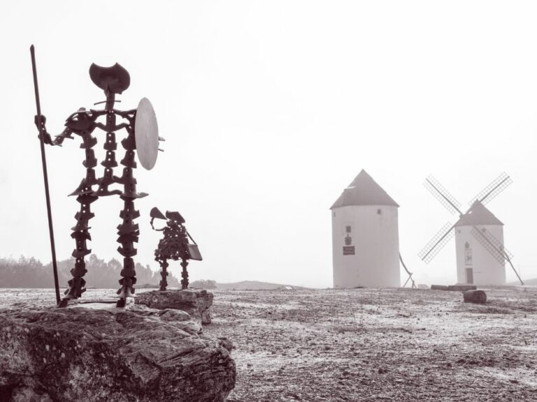 alegoría de don quijote y sancho panza en el campo junto a los molinos.