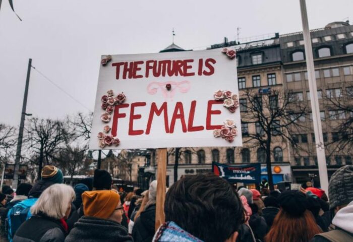 Personas en una manifestación sostienen un cartel que dice "el futuro es mujer".