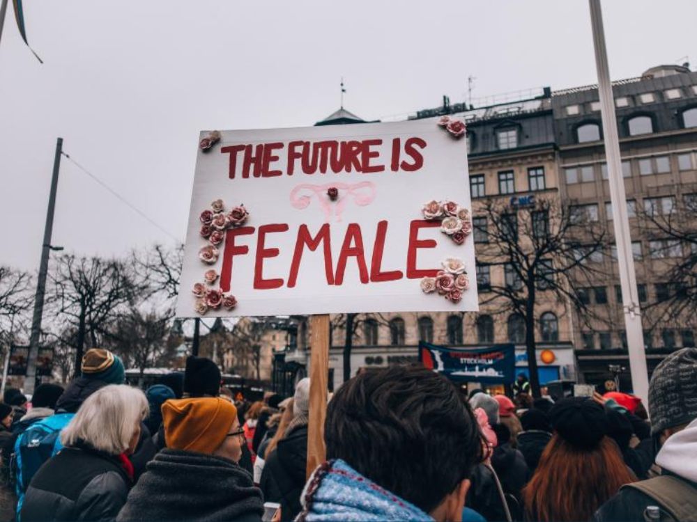 Personas en una manifestación sostienen un cartel que dice "el futuro es mujer".