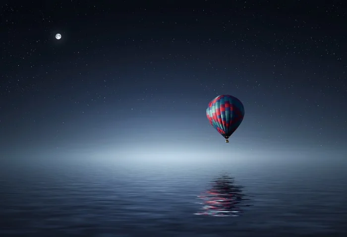Onírico: Globo aerostático sobre el agua en la noche.