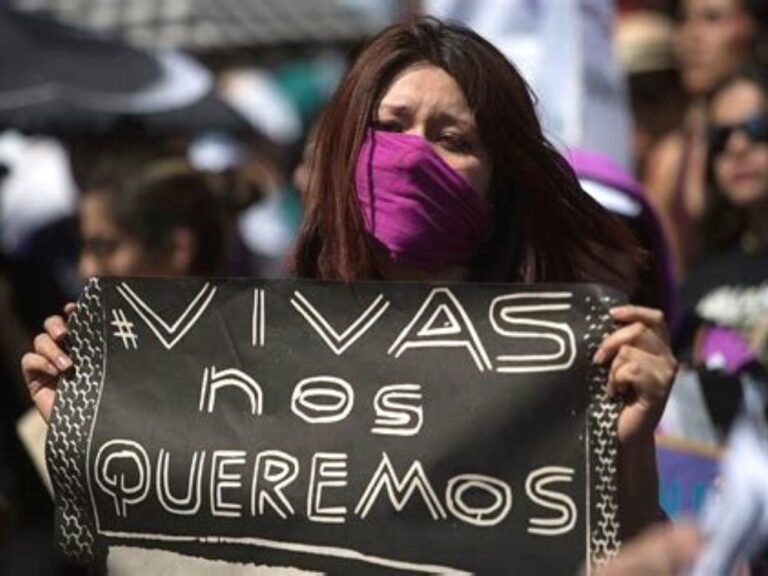 mujer con cartel en contra del feminicidio