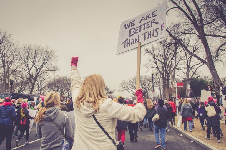 Mujer en protesta alzando un cartel: "we are better than this".