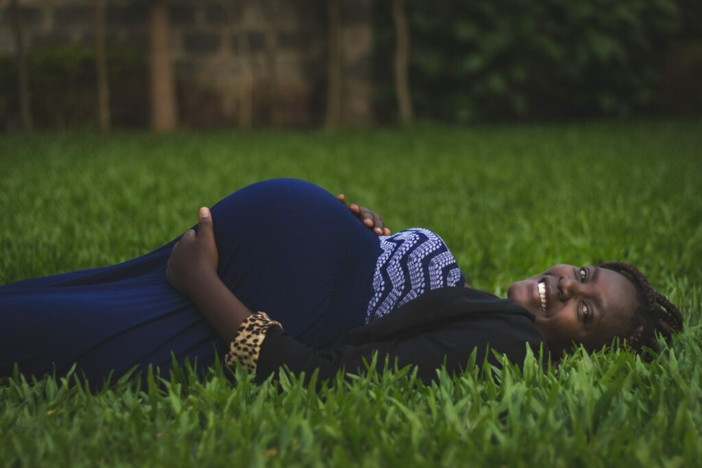 Gestación solidaria - MUJER embarazada acostada sobre la yerba