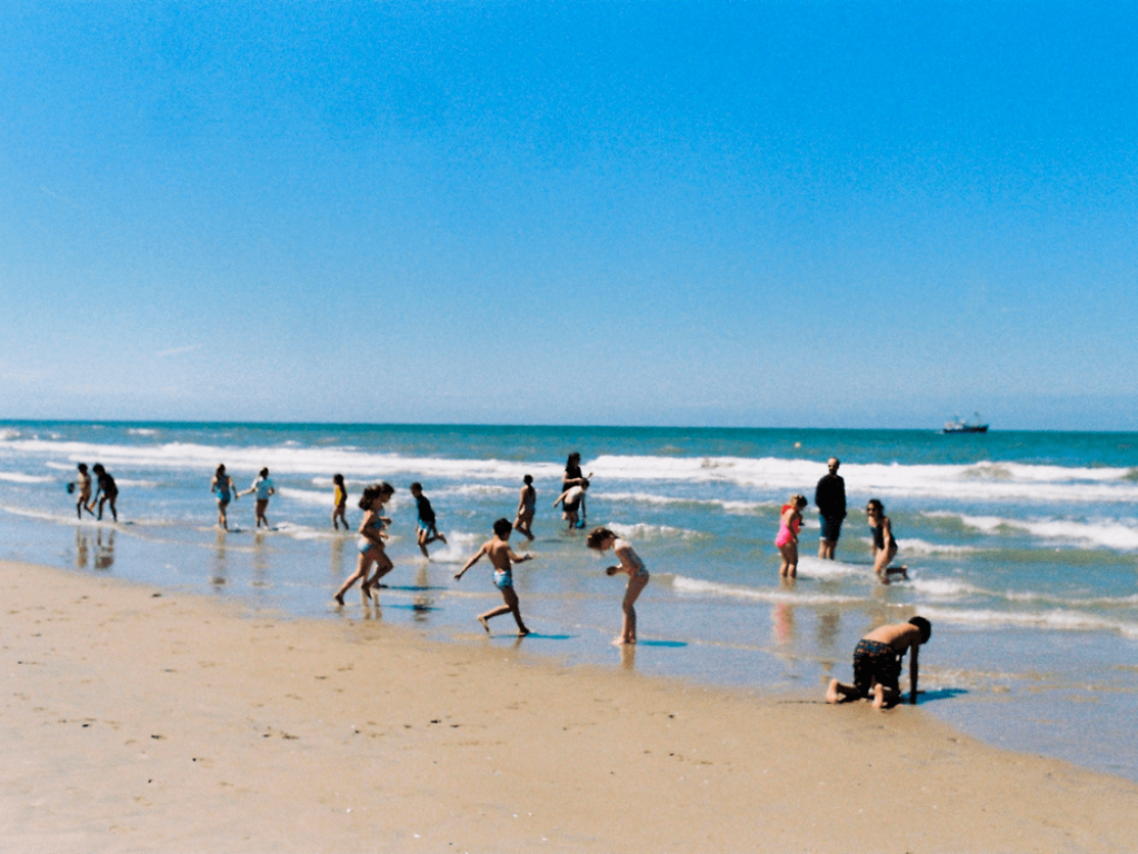 Personas bañándose en la playa.