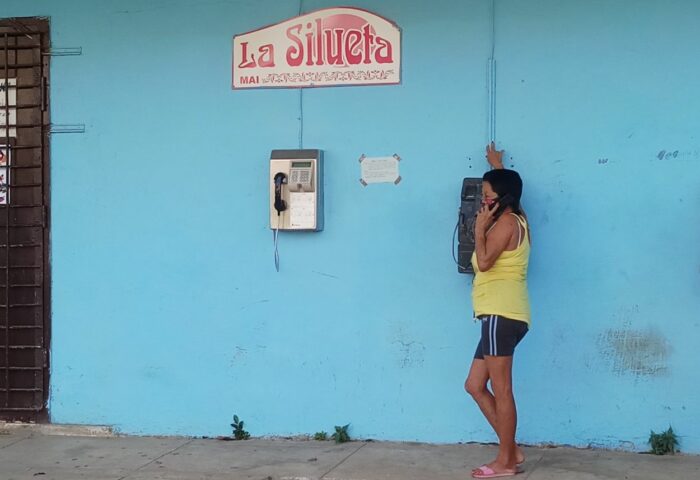 mujer hablando por un teléfono público