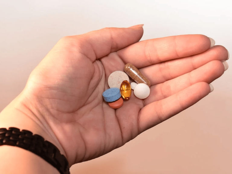 Mano de mujer sosteniendo pastillas en referencia a la perspectiva feminista en la salud pública.
