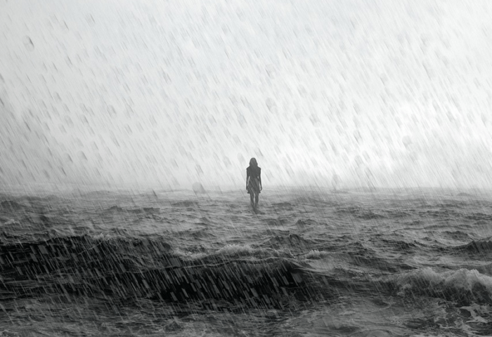 Silueta de un cuerpo femenino bajo la lluvia sobre el mar en una tormenta.