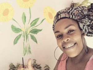 retrato de la artista cubana Afrika Reina junto a unos girasoles