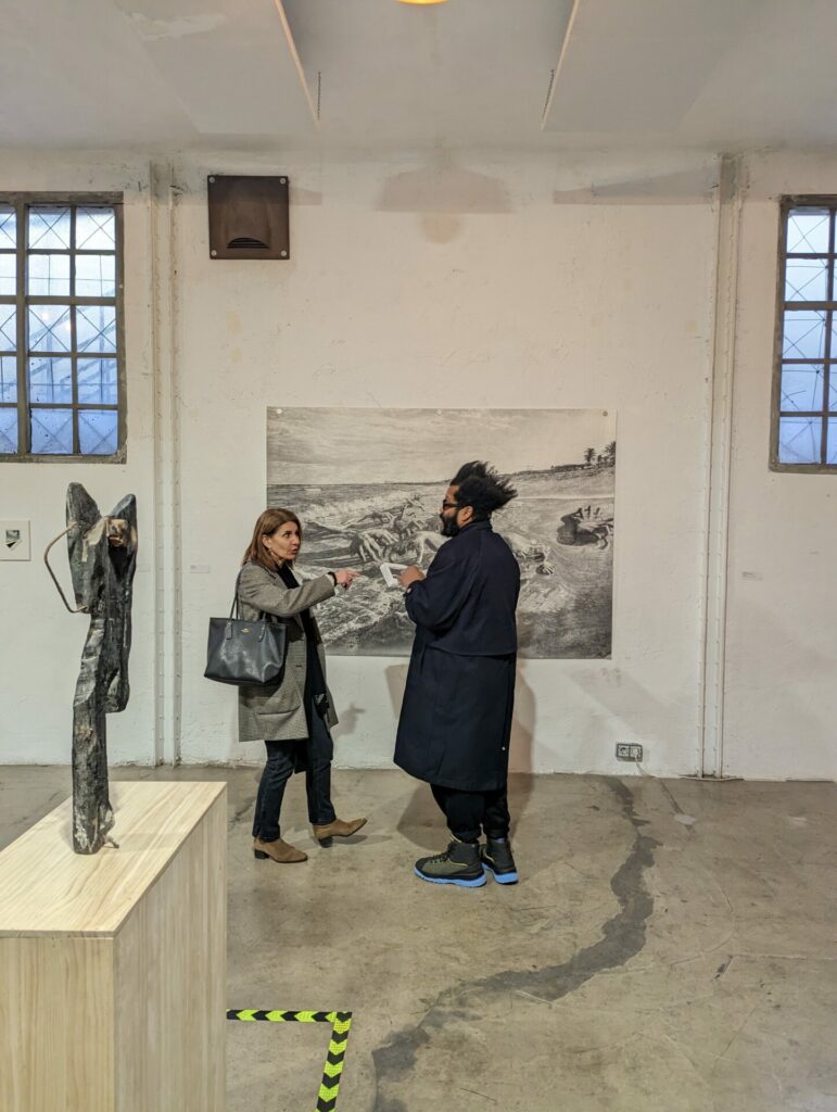 dos personas conversan cerca de una escultura
