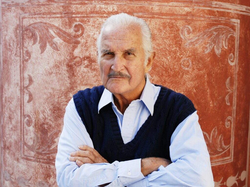 Retrato del escritor mexicano Carlos Fuentes donde posa cruzado de brazos.