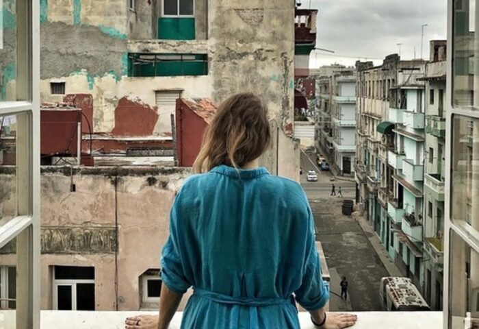 Mujer en un balcón mira la ciudad.