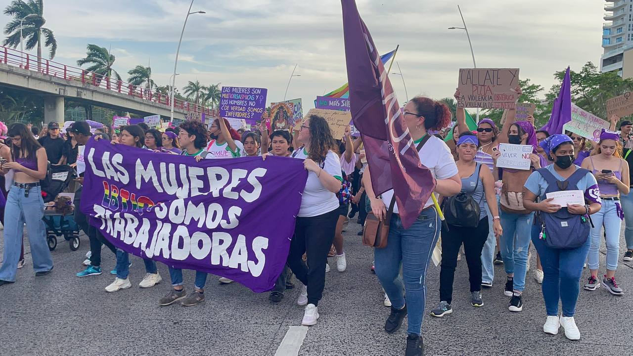mujeres sostienen cartel en favor de las trabajadoras