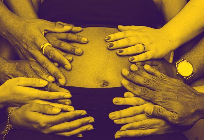 manos que abrazan la barriga de una embarazada - maternidad