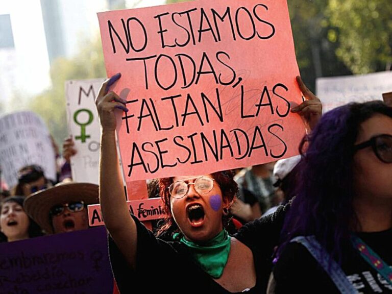mujer con cartel en manifestación contra el feminicidio