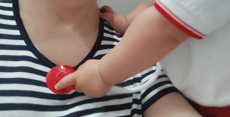 Bebé oscultando a su madre con un estetoscopio de juguete.