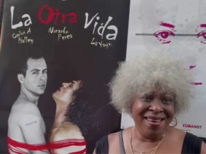 artista cubana junto a cartel de película durante Foro Intemperie
