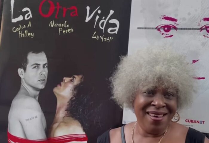 artista cubana junto a cartel de película durante Foro Intemperie
