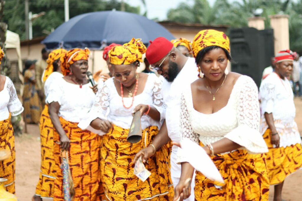 Mujeres Igbo nigerianas danzan con trajes típicos combinados en amarillo y blanco