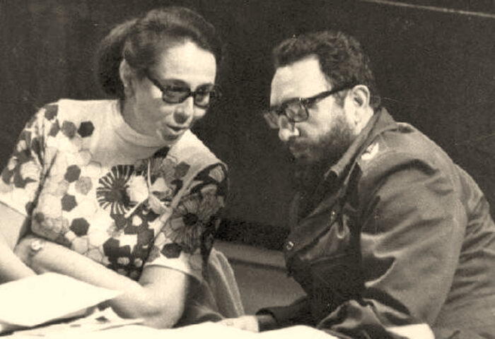 Foto de Vilma Espín y Fidel Castro sentados frente a un montón de documentos