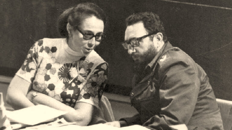 Foto de Vilma Espín y Fidel Castro sentados frente a un montón de documentos