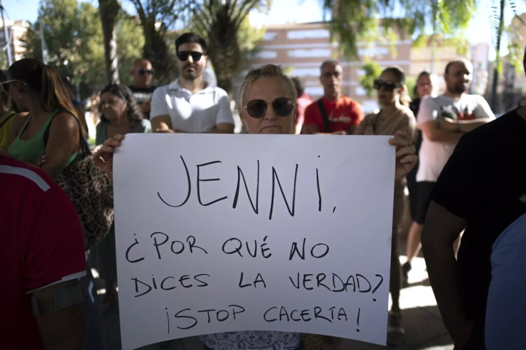 fotografía de mujer sosteniendo un cartel donde pone Jenni, ¿por qué no dices la verdad? !stop cacería!