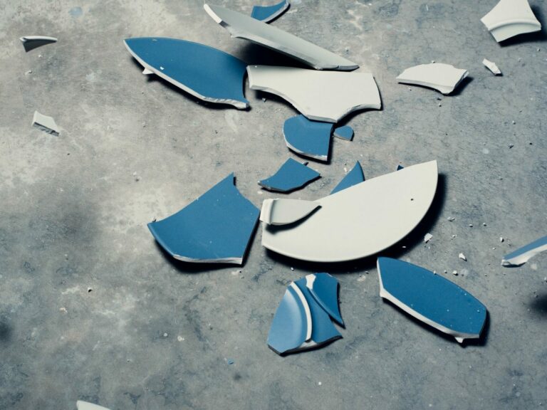 fotografía de plato de losa azul roto sobre suelo gris