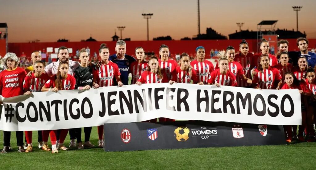 Fotografía donde puede verse al Atlético de Madrid portando un cartel de Contigo Jennifer Hermoso.