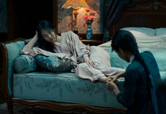 fotograma de la película coreana "La doncella". Se ve a la doncella masajeando los pies de su ama y amante.