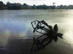 fotografía del lago de La Turbina en Ciego de Ávila. SE ve la escultura de un pez saliendo del agua.