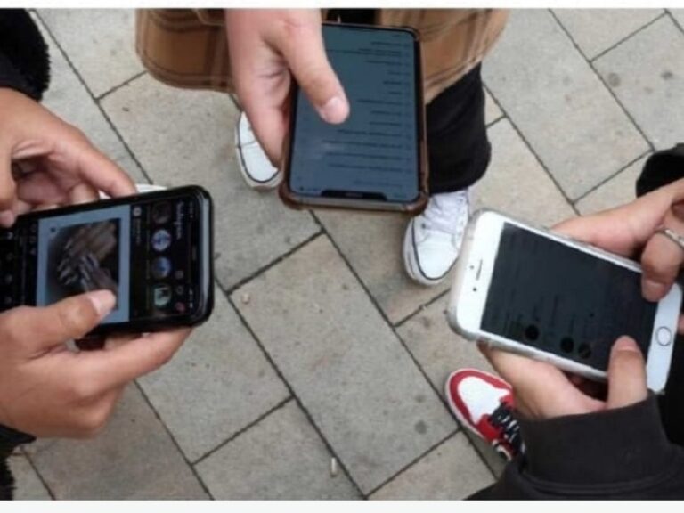 Fotografía de muchachos jóvenes mirando sus móviles.
