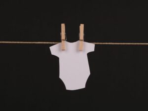 Gestación por sustitución- ropa de bebé colgando de una tendera