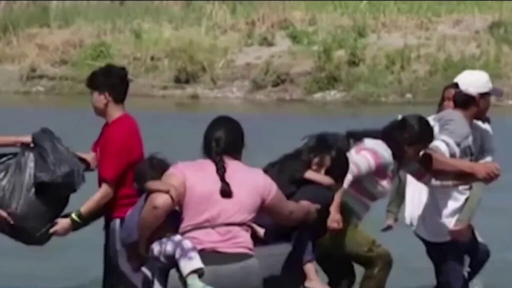Hombres y mujeres migrantes cruzando el río Bravo.
