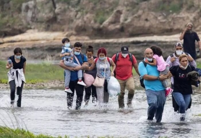 Mueres y hombres migrantes cubanos cruzando el río Bravo en travesía hacia los Estados Unidos.