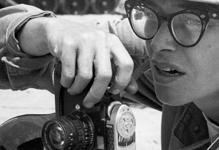 Foto de la fotorreportera Dickey Chapelle, detrás de su cámara en el campo de batalla, una de las mujeres corresponsales de guerra.