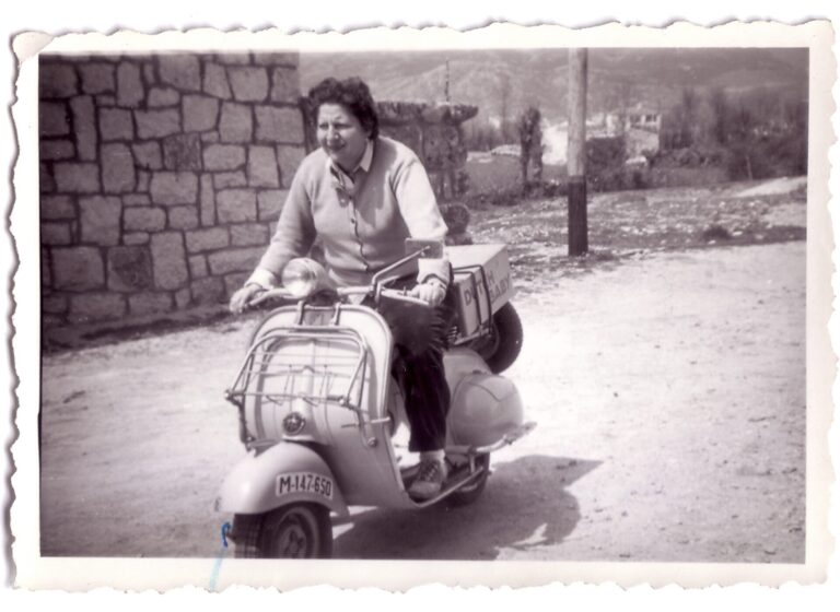 La poeta Gloria Fuertes montada en una moto vespa.