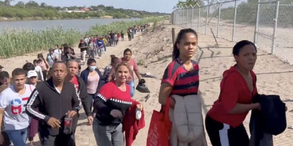 Larga fila de migrantes después de cruzar el río Bravo.