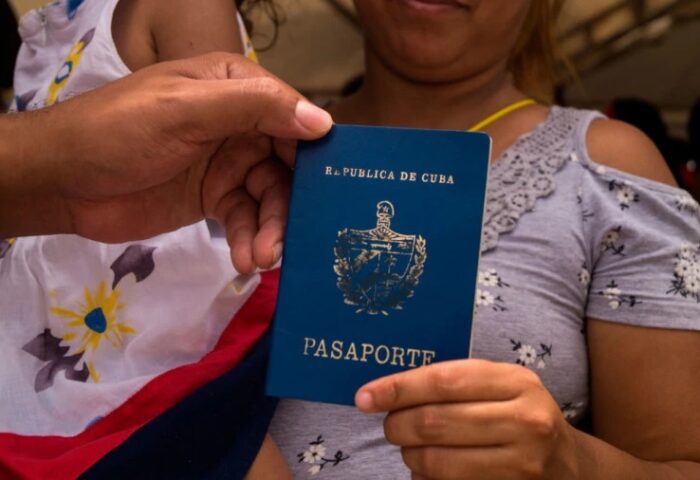 Una mujer migrante cubana muestra su pasaporte.