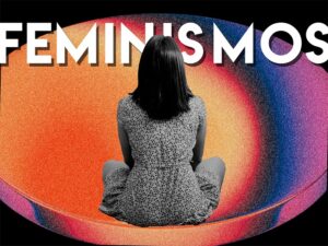 muchacha sentada de espaldas mirando un cartel que pone Feminismos.