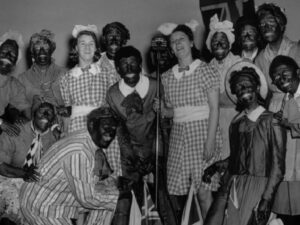 Foto tomada por Reg Speller el 5 de enero de 1943. Trabajadores de la Defensa Civil en Southwark de Londres montan un espectáculo de blackface para entretener a los hijos de los militares, los prisioneros de guerra y los trabajadores de ARP.