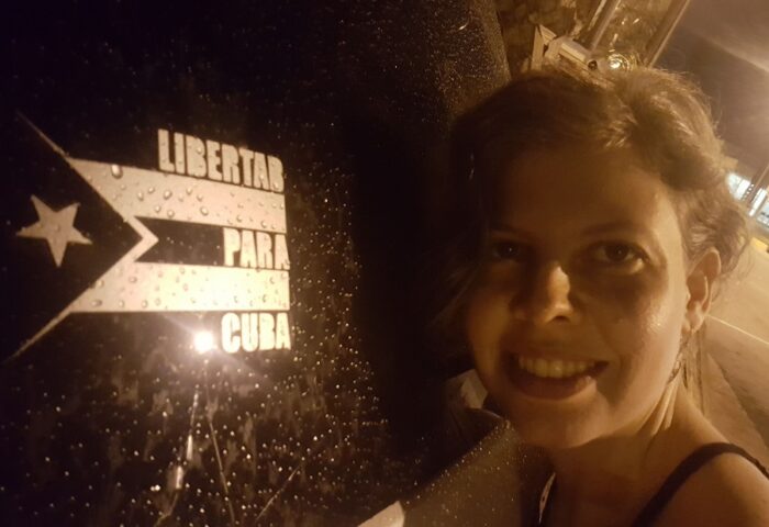 Lia villares frente a un cartel de Libertad para Cuba