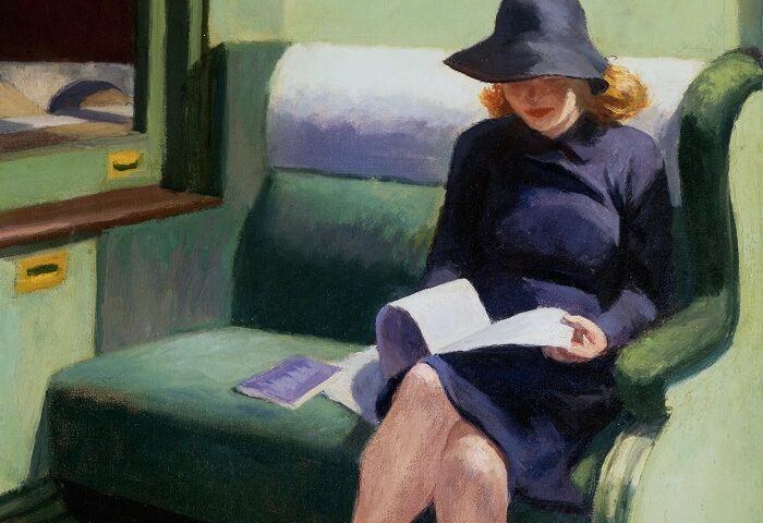 Muchacha leyendo en un tren con traje y sombrero azul.