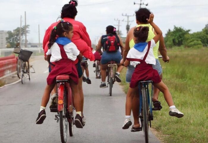 Madres cubanas llevando a sus hijas en bicicleta