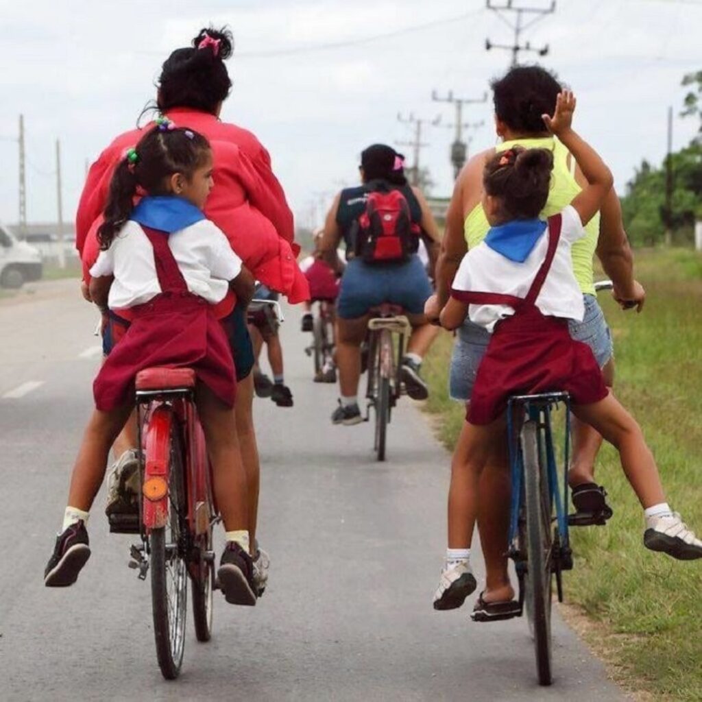 Madres cubanas llevando a sus hijas en bicicleta