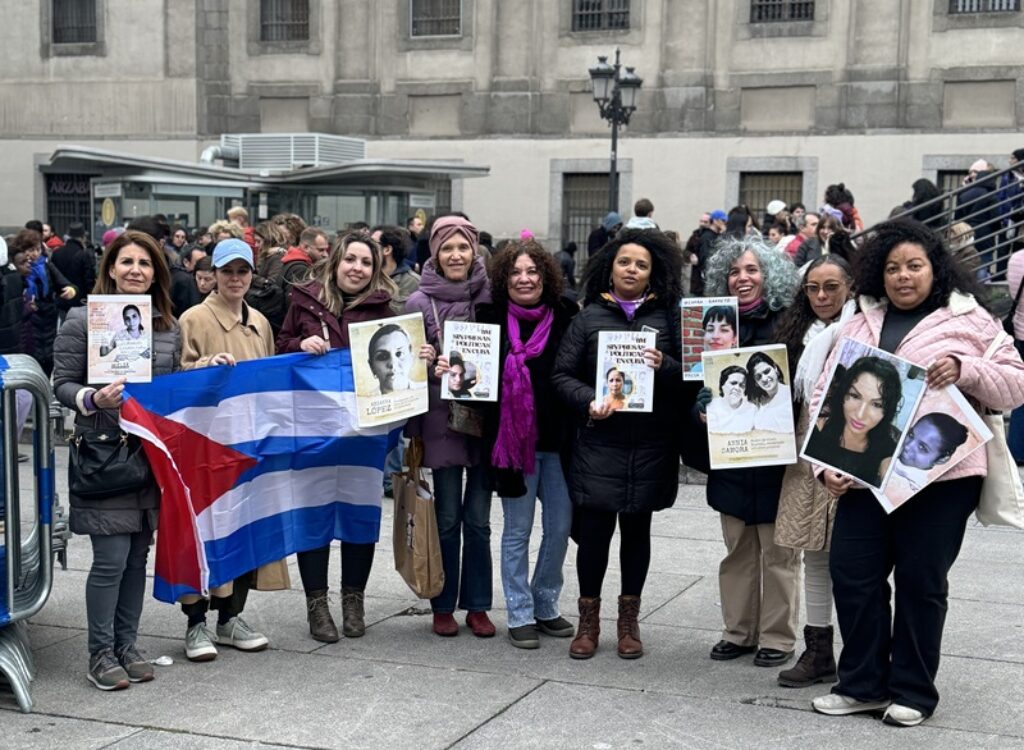 Cubanas exiliadas sostienen carteles con el retrato de presas políticas cubanas