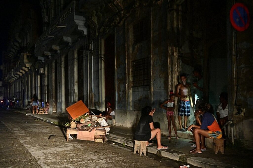 Cubanos sentados en la calle en medio del apagón.